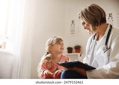 Doctor, girl and clinic consultation with clipboard, healthcare checkup and child with medical professional. Woman, sickness diagnosis and wellness result, pediatrician and treatment or patient chart - Powered by Shutterstock