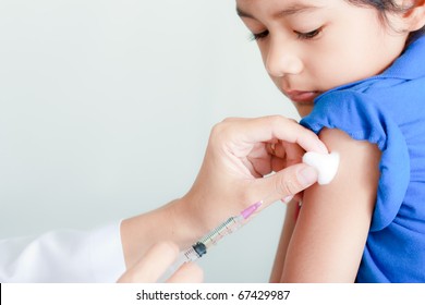 Legen gir injeksjon til guttens arm