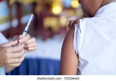 Doctor give vaccine injection to boy's arm