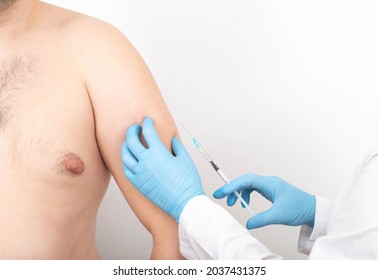 A Doctor Gives An Injection Into A Man's Forearm To Increase The Muscle Mass Of The Biceps And Triceps. Muscle Strength Injection Drugs Concept. Copy Space For Text