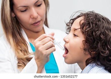 Doctor Giving A Child Homeopathic Medicine Or Vaccine