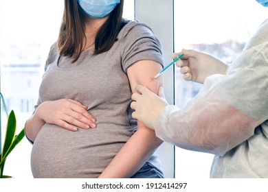 Doctor Giving COVID -19 Coronavirus Vaccine Injection To Pregnant Woman. Vaccination Young Pregnant Woman In Clinic. People Vaccination Concept.  1:1