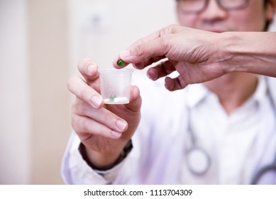 The Doctor Giving  Dosage Cup Of Medication, Medicine Concept, Selective Focus.