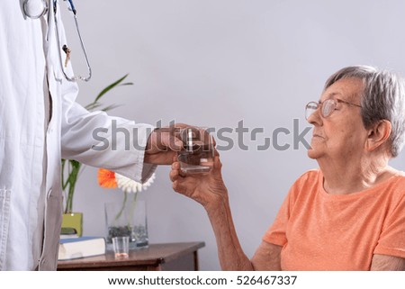 Similar – Female doctor giving medication to elderly patient