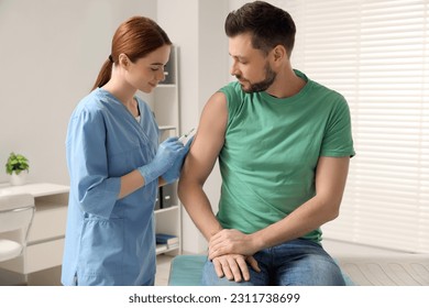 Doctor giving hepatitis vaccine to patient in clinic - Powered by Shutterstock