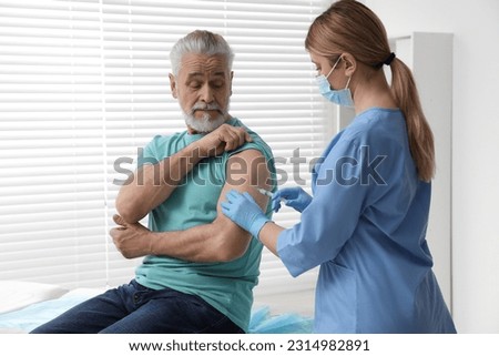 Doctor giving hepatitis vaccine to patient in clinic