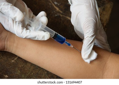 Doctor Giving An Injection To Female Student Arm.