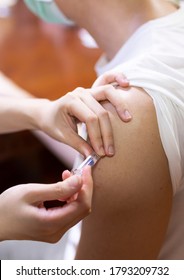 Doctor Giving An Injection To A Male Patient In The Arm. Vaccine Or Flu Shot In Injection Needle. Physician Or Nurse Giving Vaccination And Immunity To Virus, Influenza Or HPV, Covid 19, With Syringe.