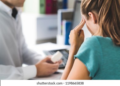 Doctor Giving Medical Help To Sick Patient With Bad Headache Or Migraine. Physician Or Pharmacist Holding Bottle Of Pills And Medicine In Appointment. Woman Suffering. Pain Killers Or Antidepressants.