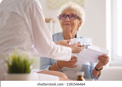Doctor giving medicine and instruction to senior woman at home