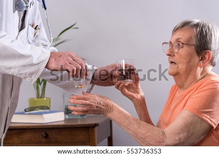 Similar – Female doctor giving medication to elderly patient