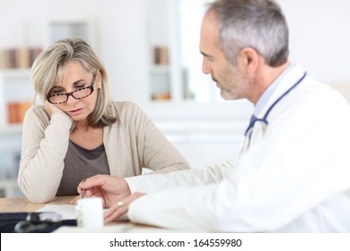 Doctor Giving Medicine To Senior Woman For Arthritis Pain