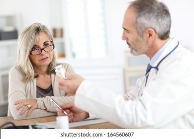 Doctor Giving Medicine To Senior Woman For Arthritis Pain