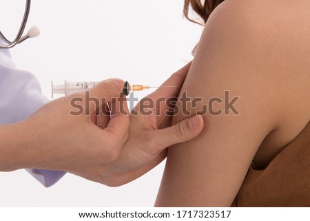 Doctor giving a patient injection subcutaneous arm injection vaccination isolated on a white background.