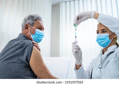 Doctor Giving A Senior Man Vaccine. Immunization Of Older Population.