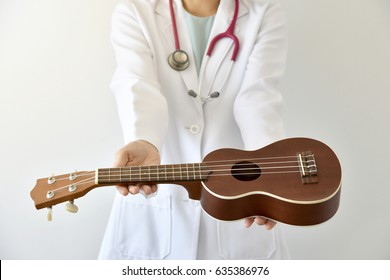 Doctor Giving Ukulele (musical Instrument), Music Therapy Concept. (Selective Focus)