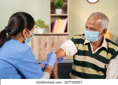 Doctor giving vaccination shot to elderly patient by syringe or injunction at home while both worj face mask - concept of home health check to seniors during coronavirus covid-19 pandemic - Powered by Shutterstock