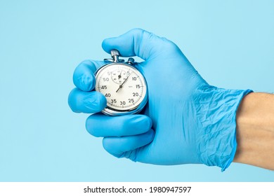 Doctor in glove holds stopwatch in his hand. Fast medical assistance and consultation concept. - Shutterstock ID 1980947597