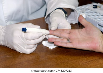 A Doctor With Gloves Does A Blood Test On A Patient