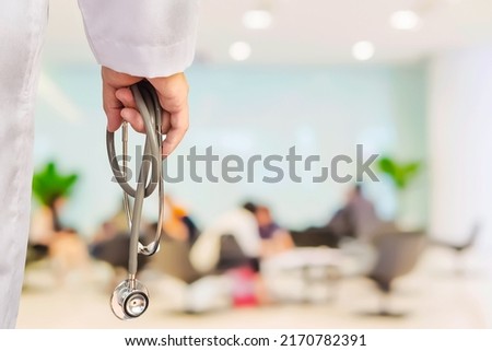 Doctor is going to examine his patient using his stethoscope over sitting people

