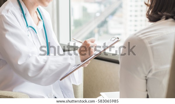 Doctor (gynecologist or psychiatrist)\
consulting and diagnostic examining woman patient\'s health in\
medical clinic or hospital healthcare service\
center