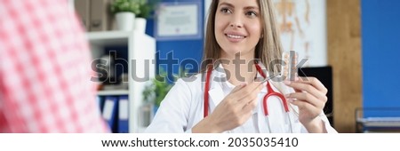 Doctor gynecologist showing woman patient blister with pills in clinic [[stock_photo]] © 