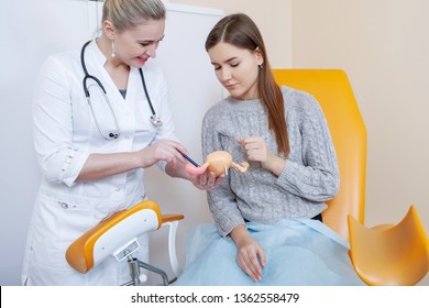 Doctor Gynecologist Talking To A Female Patient In An Orange Chair In A Medical Office.