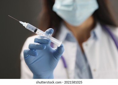 Doctor hand in blue gloves holds vaccine closeup