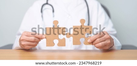 Doctor hand connecting couple puzzle piece, wooden jigsaw in hospital. Teamwork, Idea, Solution, challenge, success, Health, Medical and strategy concepts