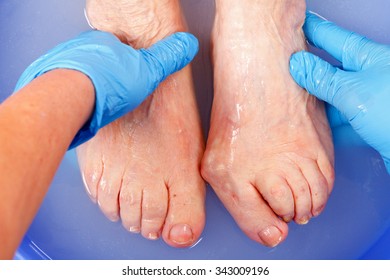 Doctor hand examining an elderly patient's foot