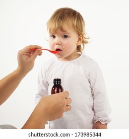 Doctor Hand Giving Spoon Dose Of Medicine Liquid Drinking Syrup To Child  