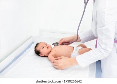 Doctor Hand Hold Tiny Asian Newborn Baby Sick Sleeping During Examine By Pediatrician Doctor With Stethoscope, Doctor Monitoring Heart Pulse Rate Adorable Infant In Clinic, Baby Health Care Concept .