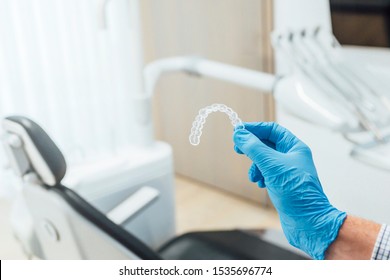 Doctor Hand Holding A Clear Dental Aligner