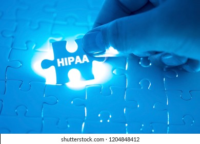 Doctor hand holding a jigsaw puzzle with HIPAA word. Concept Healthy.