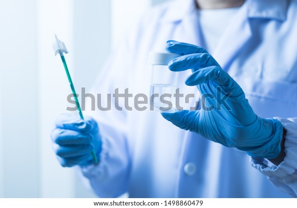 Doctor hand holding liquid base cytology set on\
blue background.Gynecologist working for vaginal and cervix pap\
smear patient in the obstetrics and gynecology department.Medical\
concept.