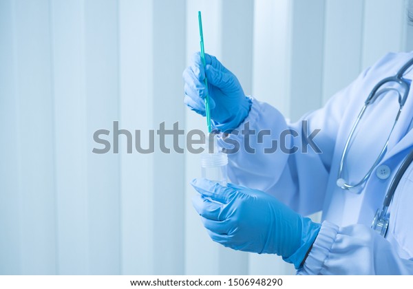 Doctor hand holding liquid base cytology set on\
blue background.Gynecologist working for vaginal and cervix pap\
smear patient in the obstetrics and gynecology department.Medical\
concept.