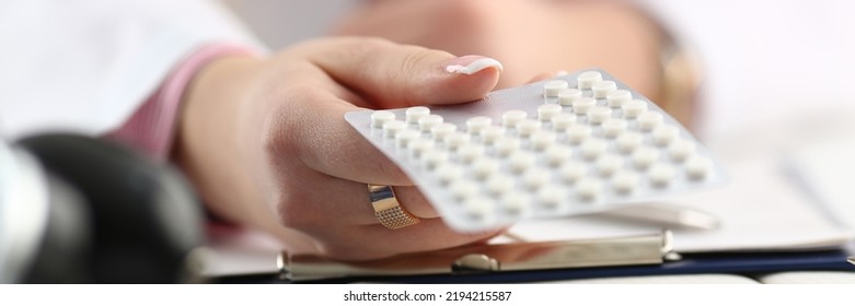 Doctor Hand Holding Package Of Pills In Workplace Closeup