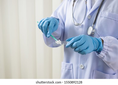 Doctor hand holding spatula and glass slide cytology set.Gynecologist working for vaginal and cervix pap smear patient in the obstetrics and gynecology department.Medical concept.