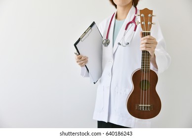 Doctor Hand Holding Ukulele (musical Instrument), Music Therapy Concept. (Selective Focus)