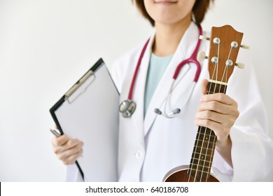 Doctor Hand Holding Ukulele (musical Instrument), Music Therapy Concept. (Selective Focus)