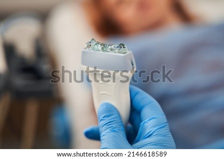 Doctor hand holding ultrasound probe with coupling gel on it and prepare for diagnostic