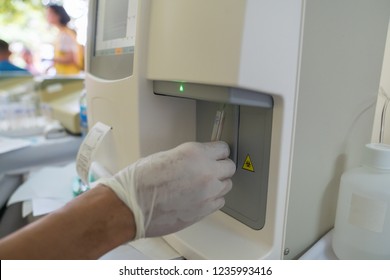Doctor hand performing a blood test with hematological counter machine - Shutterstock ID 1235993416