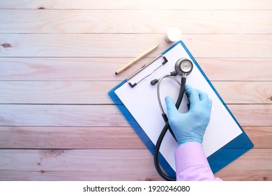 Doctor Hand In Protective Gloves Holding Stethoscope Top Down 