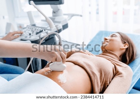 Doctor hand with ultrasonic during ultrasound medicine examination of pregnant patient. Maternity, pregnancy, fertility concept. Future mom checking on the embryo