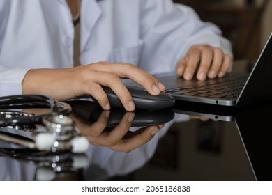 Doctor Hand Using Wireless Mouse Working With Laptop Computer At Medical Office.