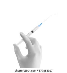 Doctor hand in white glove hold syringe with preparation jet from the needle. Medical man holding injector with drugs in arm. Surgeon with flu intravenous vaccine. Botox injection syringe therapy