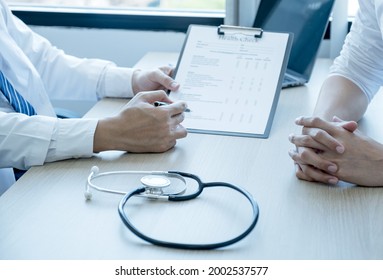 The Doctor Hand Write Report And Explained Examination Results To The Patient Man, Healt Care And Medical Checkup Concept.