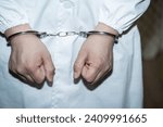 Doctor in handcuffs wearing Lab Coat