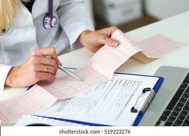 Doctor Hands With Cardiogram Chart On Clipboard Pad Fill Medical History With Silver Pen. Cardio Therapeutist Assistance, Physician Make Cardiac Physical, Pulse Measure Document, Arrhythmia Idea