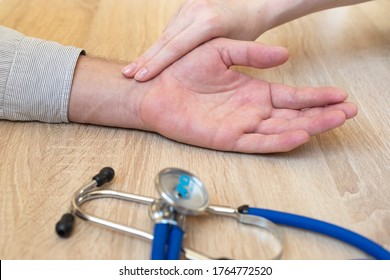 Doctor Hands Feeling Pulse On Female Wrist